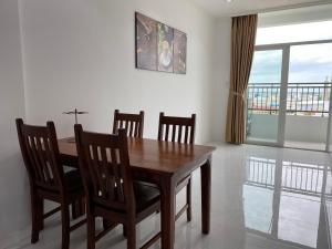 a dining room with a wooden table and chairs at High-class apartment with beautiful river view in Long Xuyên