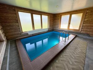 a lap pool in a house with windows at Vonadziņi in Stāmeriena