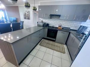 a kitchen with blue cabinets and a counter top at Luxury 3 Bedroom in Bondi Beach Resort in Shelly Beach +2 photos