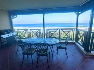 a table and chairs on a balcony with the ocean at Luxury 3 Bedroom in Bondi Beach Resort in Shelly Beach