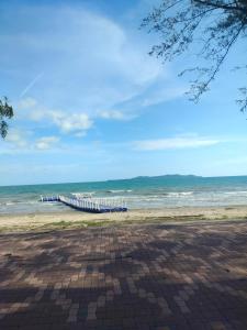 a pier on the beach with the ocean in the background at ไกล้ทะเลอยู่แบบธรรมชาติ in Ban Khao Yai Chum