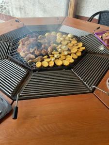 a grill with different types of food on it at Aniiza Apartman 2 in Örvényes