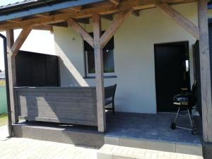 a patio with a bench under a wooden pergola at Domki Arcadia in Gąski