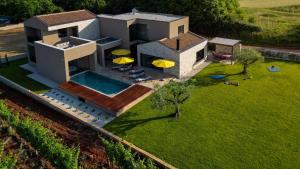 卡斯特里尔Luxury Villa Deneb with pool near Porec的享有带游泳池和遮阳伞的房屋的空中景致