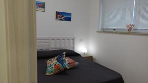 sypialnia z łóżkiem z poduszką i oknem w obiekcie Stella di Mare w mieście Balestrate