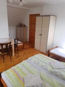 a bedroom with a bed and a table and a cabinet at Pokój 4osobowy in Swornegacie