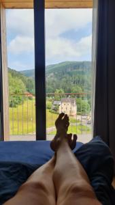 特鲁特诺夫Krásný apartmán u sjezdovky v Janských Lázních的一名赤裸上身的男子躺在床上，望着窗外