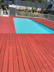 a swimming pool with a red floor and a red deck at Appartement avec piscine in Saint-Laurent-du-Var