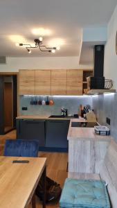 特鲁特诺夫Krásný apartmán u sjezdovky v Janských Lázních的一个带木制橱柜和桌子的大厨房