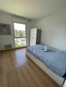 a bedroom with a bed and a large window at Appartement avec piscine in Saint-Laurent-du-Var