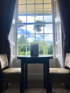 a table in front of a window with a laptop on it at Royal Victoria Hotel Snowdonia in Llanberis