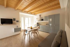 a kitchen and a living room with a table and chairs at La casa nel verde in Recanati