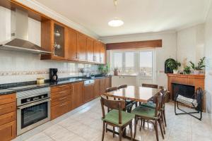 a kitchen with wooden cabinets and a table and chairs at Casa do Olival in Vila Flor