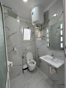a bathroom with a toilet and a sink at Vila Roan in Vlorë +56 photos