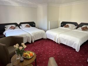 a hotel room with two beds and a table with a bowl of fruit at Hotel Eikenhof in Aalter +29 photos