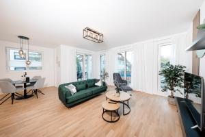 a living room with a green couch and a table at koCASA-Apartments 01, City-Center Böblingen, Stellplatz, Balkon, Waipu-Tv in Böblingen