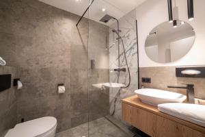 un bagno con doccia, lavandino e WC di Hotel Alpenblick a Filzmoos