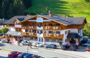 un grande edificio con auto parcheggiate in un parcheggio di Hotel Alpenblick a Filzmoos