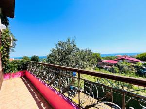 a balcony with a black railing and a view of the ocean at BRUNETTE BEAUTIES Guesthouse & Studio Sinemorets in Sinemorets