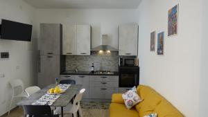 kuchnia ze stołem i żółtą kanapą w obiekcie Stella di Mare w mieście Balestrate