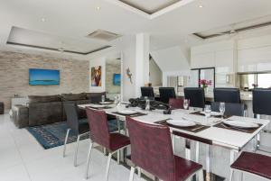 a dining room with a long table and chairs at Villa Oceane in Thong Son Beach