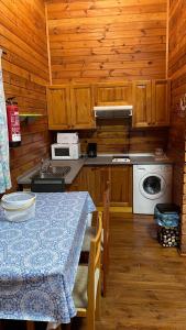 a kitchen with a table and a stove and a microwave at Casas Rurales Tabla Honda in El Robledo