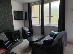 Una sala de estar con un sofá y una ventana. en La maison de Nadège, en Lion-sur-Mer 3 fotos más