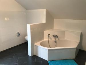 a white bathroom with a tub and a toilet at ARLALPIN in Pettneu am Arlberg +52 photos