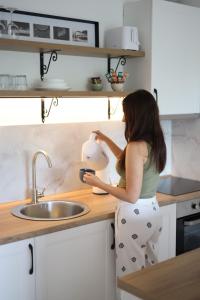 Una donna è in piedi in una cucina con un frullatore di Studio Apartman Boho a Sombor