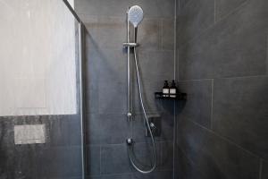 a shower with a shower head in a bathroom at koCASA-Apartments 01, City-Center Böblingen, Stellplatz, Balkon, Waipu-Tv in Böblingen +33 photos