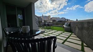 a patio with a table and chairs on a balcony at Magnólia Residence in Funchal