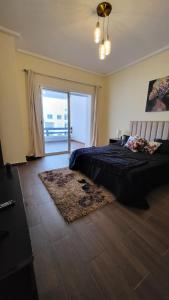 a bedroom with a large bed and a large window at Cité Marine in Mansouria +14 photos