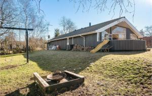 un patio trasero con una casa y un parque infantil en Gorgeous Home In Græsted With Sauna, en Græsted 7 fotos más