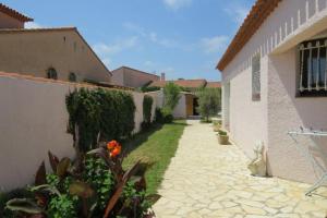 une cour d'une maison avec une cour fleurie dans l'établissement Villa familiale piscine privée 6 personnes Proche plage 6PC7, à Saint-Laurent-de-la-Salanque