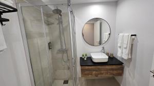 a bathroom with a shower and a sink and a mirror at Magnólia Residence in Funchal +16 photos