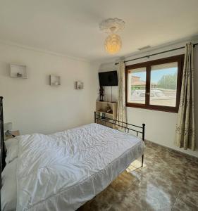 une chambre blanche avec un lit et une fenêtre dans l'établissement Villa familiale piscine privée 6 personnes Proche plage 6PC7, à Saint-Laurent-de-la-Salanque 17 autres photos
