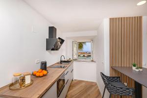 a kitchen with white walls and a wooden counter top at SoHo apartment on the waterfront in Mlini +10 photos
