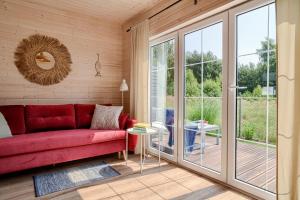a living room with a red couch and sliding glass doors at Domki Podniebo in Jarosławiec