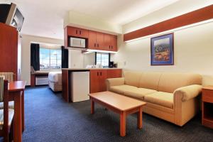 
a living room filled with furniture and a kitchen at Rincon Inn and Suites in Rincon

