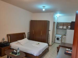 a bedroom with a bed and a table and a kitchen at La Luna in Bangui