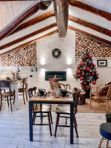 a dining room with a table and a christmas tree at Maison de la montagne - Chambres & Relax in Arvier