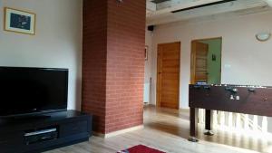 a living room with a brick wall and a flat screen tv at Karwica 39G Mazury jezioro Nidzkie in Karwica