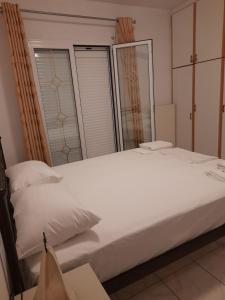 a large white bed in a room with windows at Hellenic Sun in Lassi