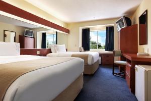 Rincon的住宿－林孔套房酒店，酒店客房配有两张床和一张书桌