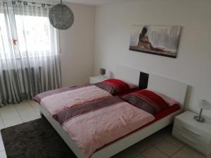 a bedroom with a bed with red sheets and a window at Cervantes in Landstuhl
