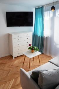 a living room with a couch and a dresser at Apartament Różowy Jeleń in Gliwice