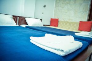 two beds with blue sheets and white towels on them at Erifili Kallithea in Kallithea Halkidikis