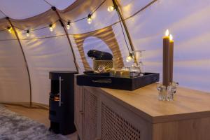 a room with a table with candles and a tent at Holmegaard vin og glamping in Dannemare