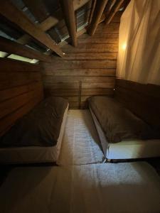 a small room with two beds in a cabin at Elämyksellinen majoitus aitassa in Kokkola