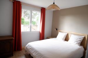 a bedroom with a bed and a window with red curtains at maison familiale proche plage in Quiberville